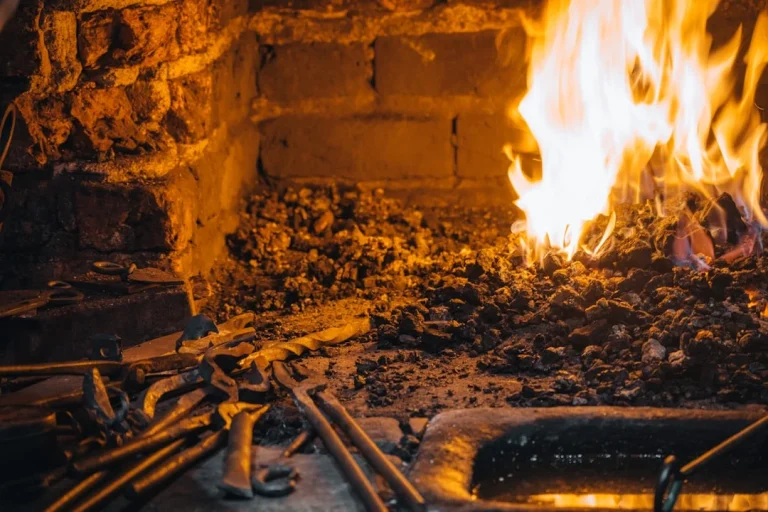Blacksmith forge with glowing embers and tools.