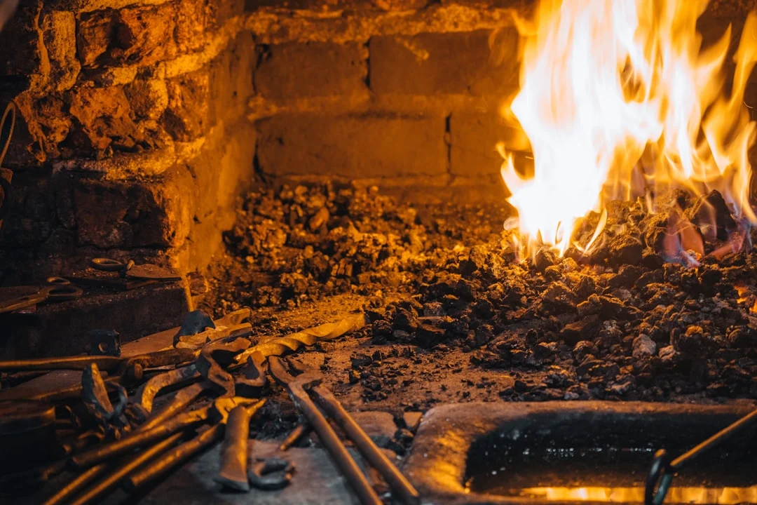 Blacksmith forge with glowing embers and tools.